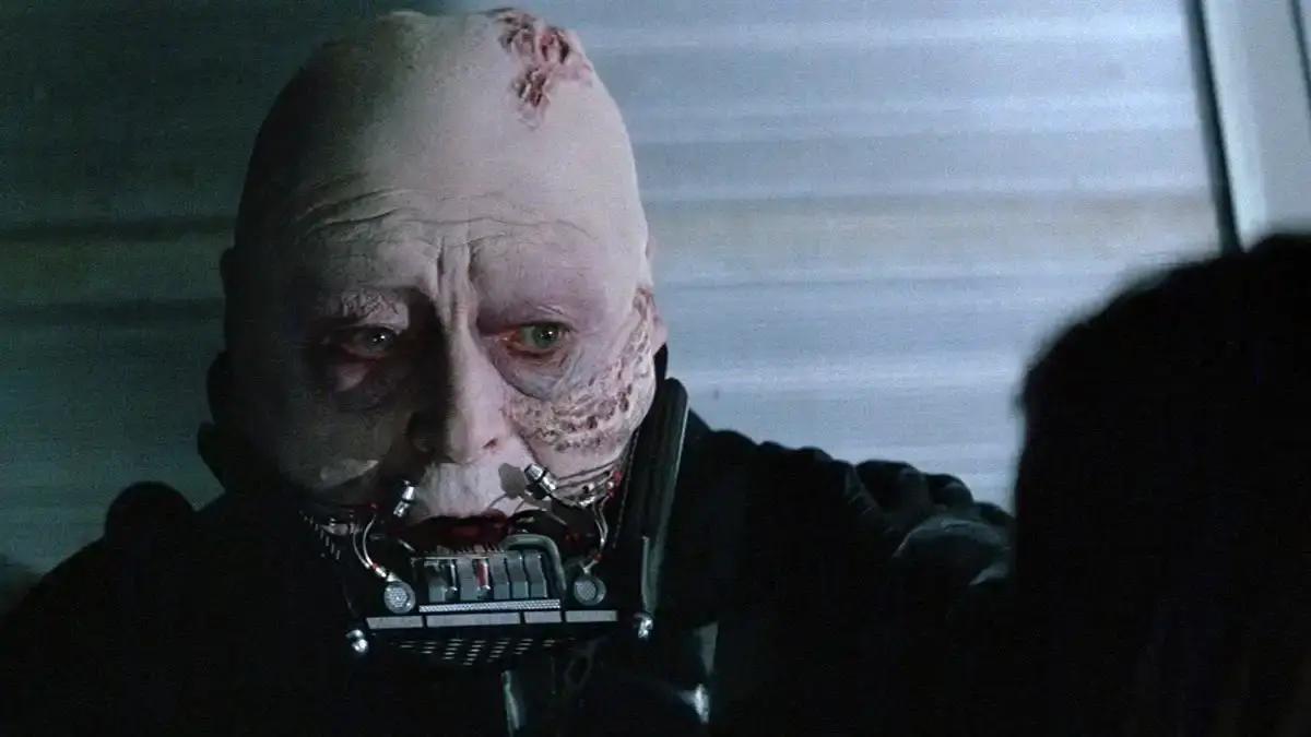 A scarred Darth Vader without his helmet, wearing his breathing mask.